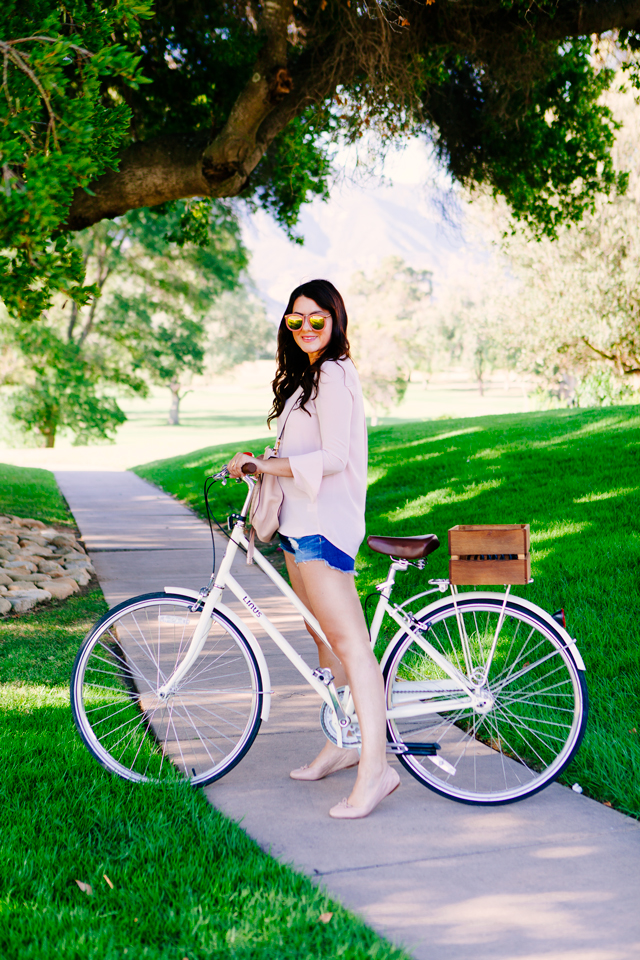 Kendi Everyday wears blush bell sleeve top, riding bikes in Ojai, California