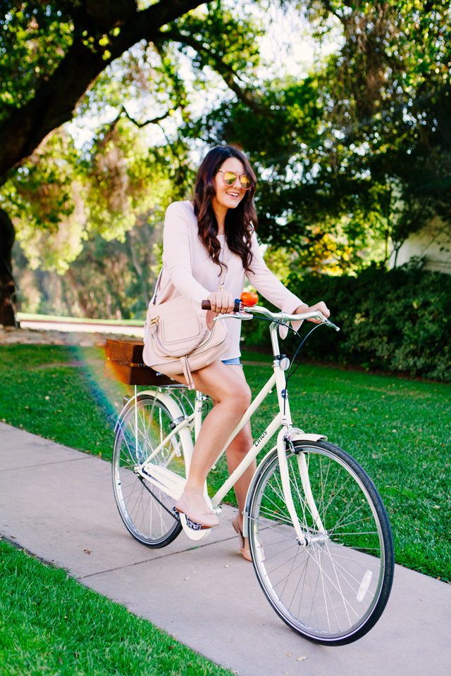 Kendi Everyday wears blush bell sleeve top, riding bikes in Ojai, California