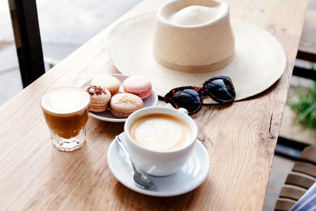 Macrons and coffee with summer hat and sunglasses