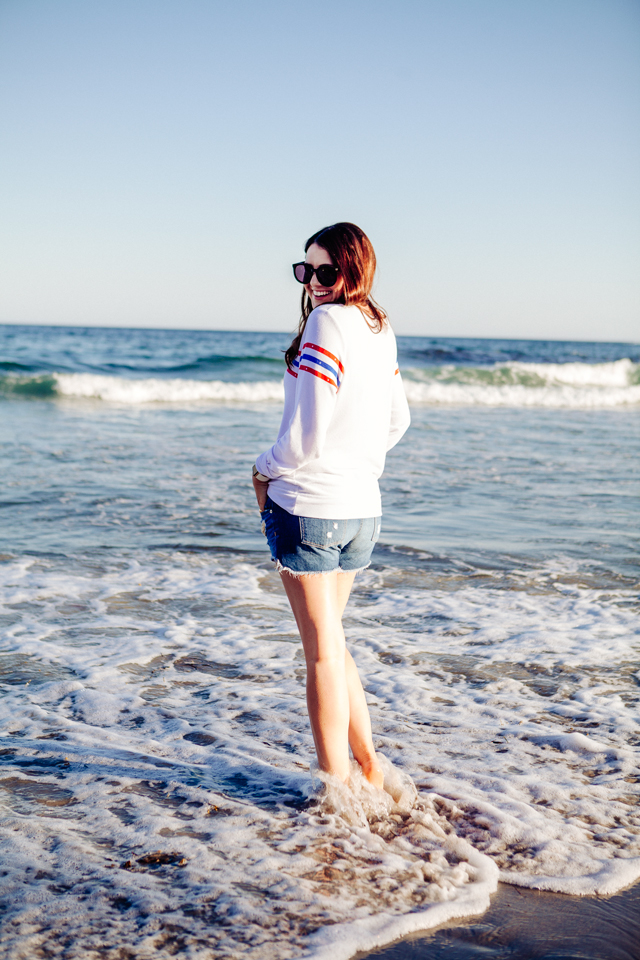 Kendi Everyday wearing a Wildfox Striped Sweatshirt and denim cut Offs on the beach