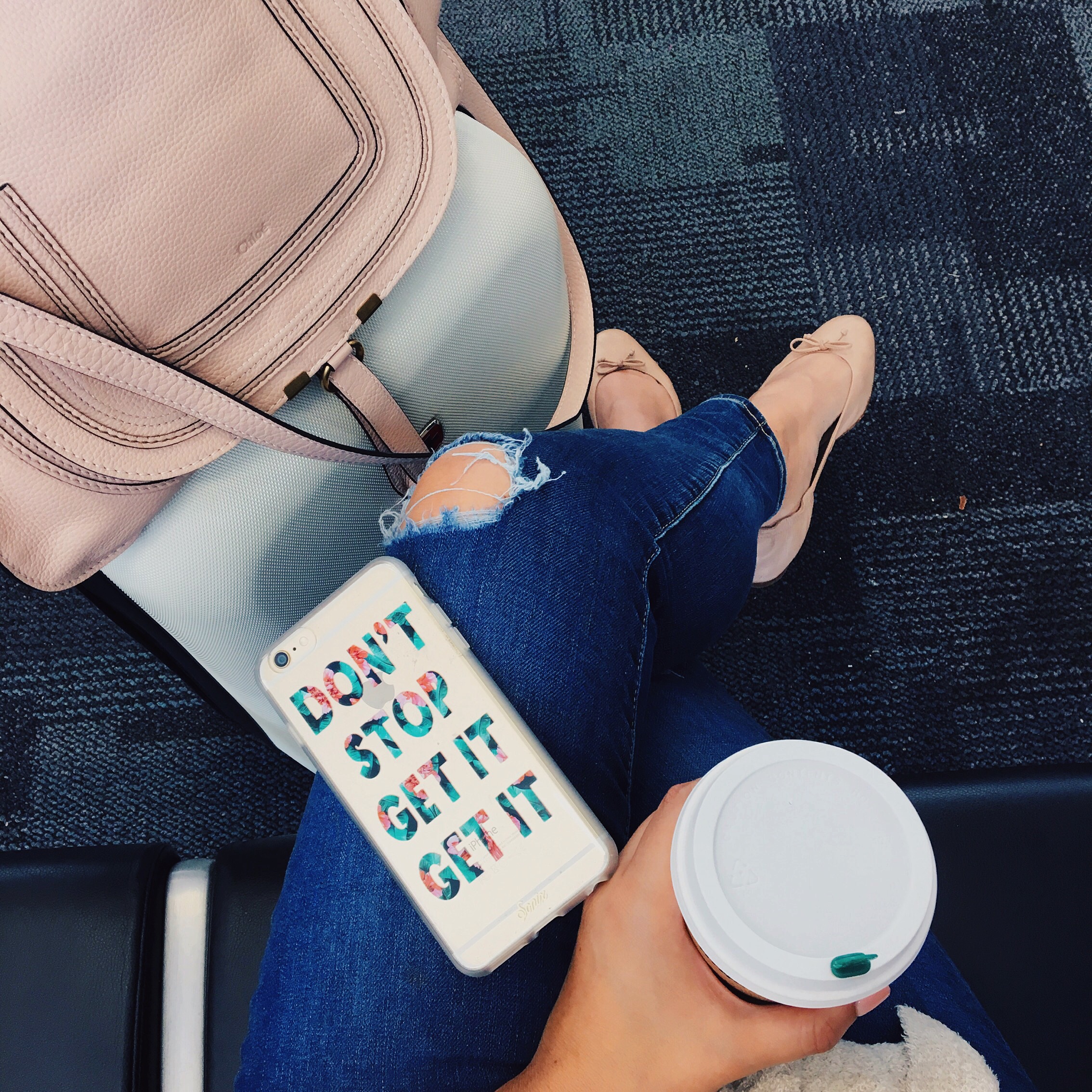 Airport outfit with distressed denim, blush Chloe Marcie bag, nude flats and white rolling carry on, seen on Kendi Everyday's instagram