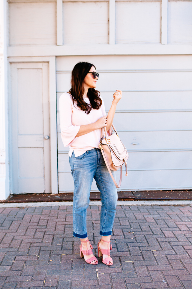 Pink Bell sleeve sweater with raw edge denim and madewell tassel pink suede heels.