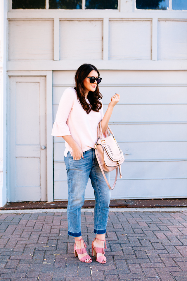 Pink Bell sleeve sweater with raw edge denim and madewell tassel pink suede heels.