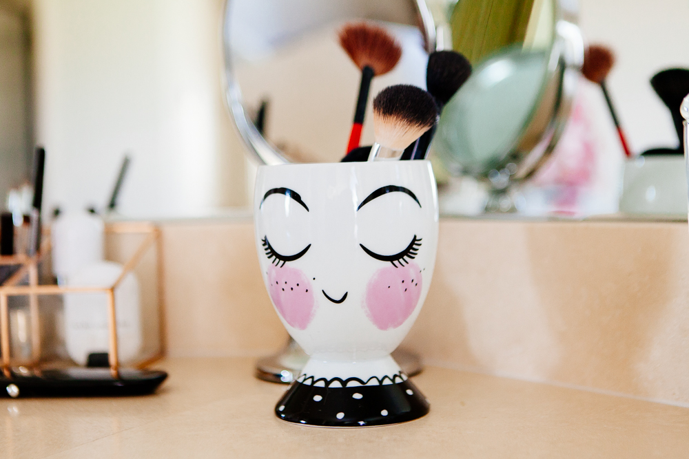 Painted lady ceramic cup for makeup brushes.