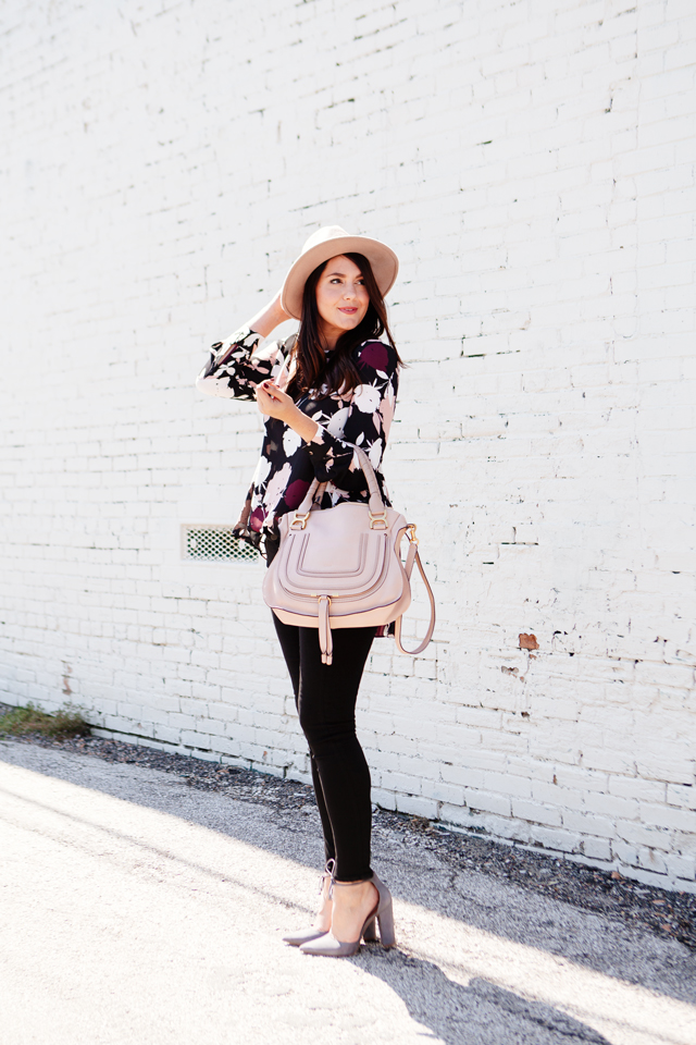 Floral blouse with black skinny jeans and blush hat and purse on Kendi Everyday