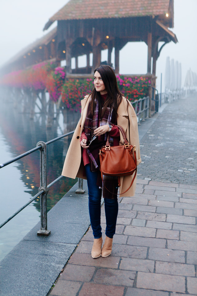 Burgundy sweater with plaid scarf and camel coat in Lucerne.