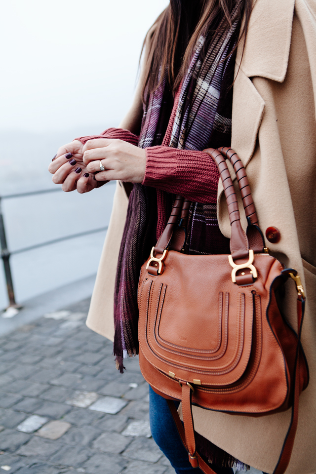 Burgundy sweater with plaid scarf and camel coat in Lucerne. 