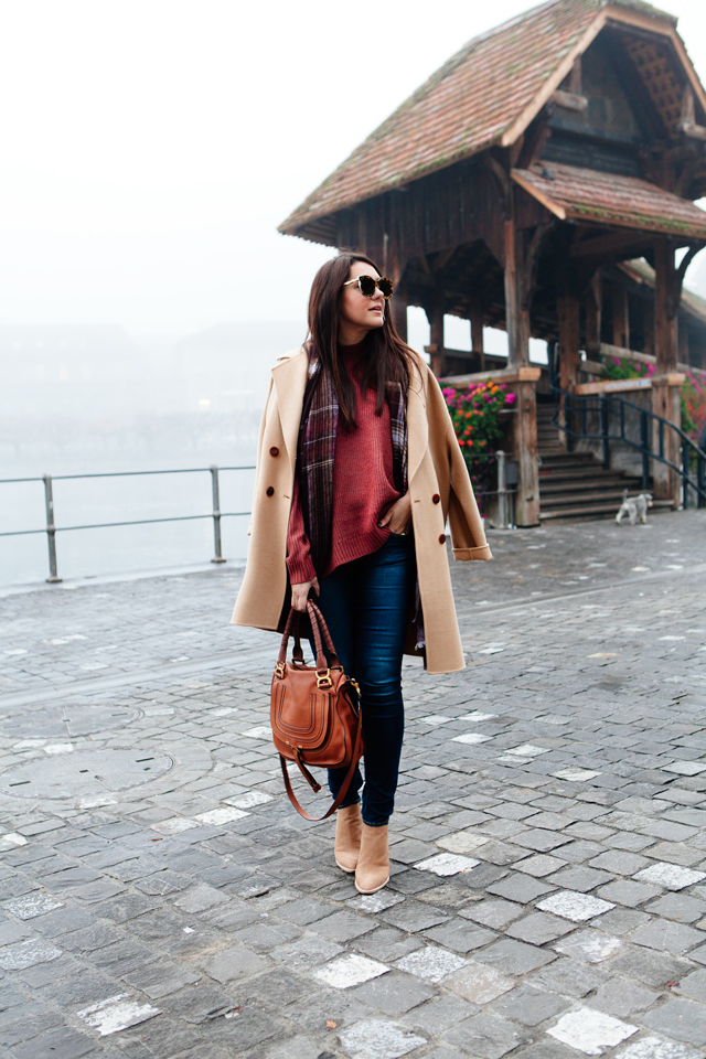 Burgundy sweater with plaid scarf and camel coat in Lucerne. 