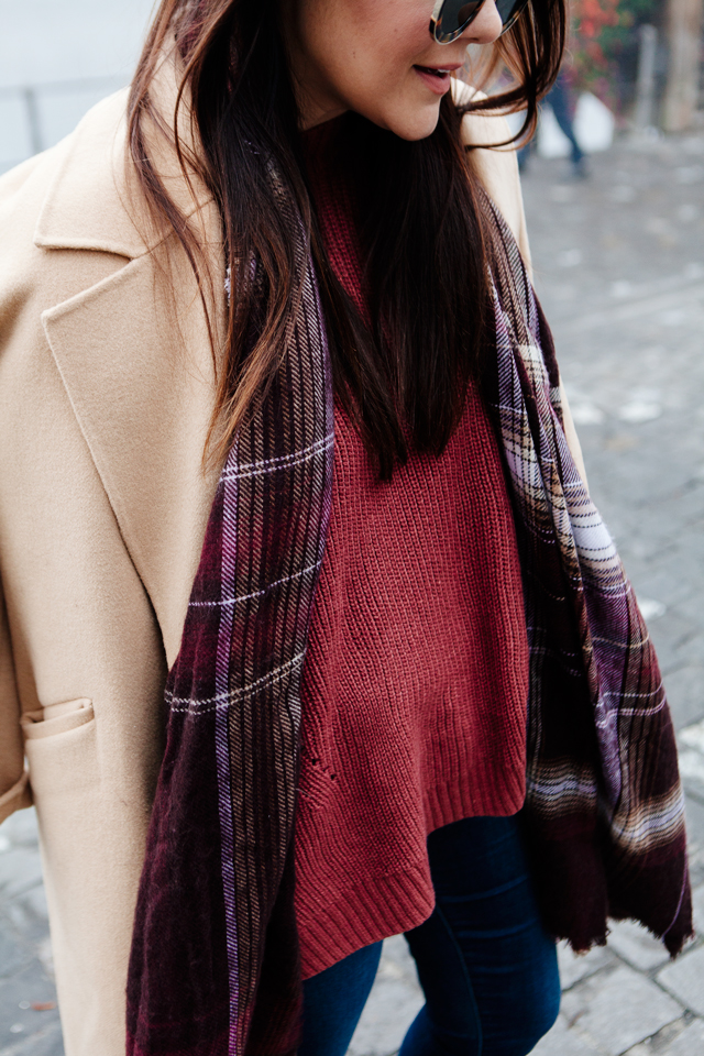 Burgundy sweater with plaid scarf and camel coat in Lucerne. 