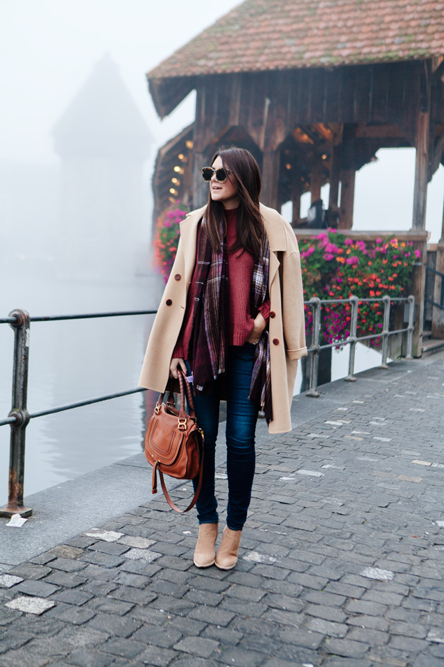 Burgundy sweater with plaid scarf and camel coat in Lucerne. 