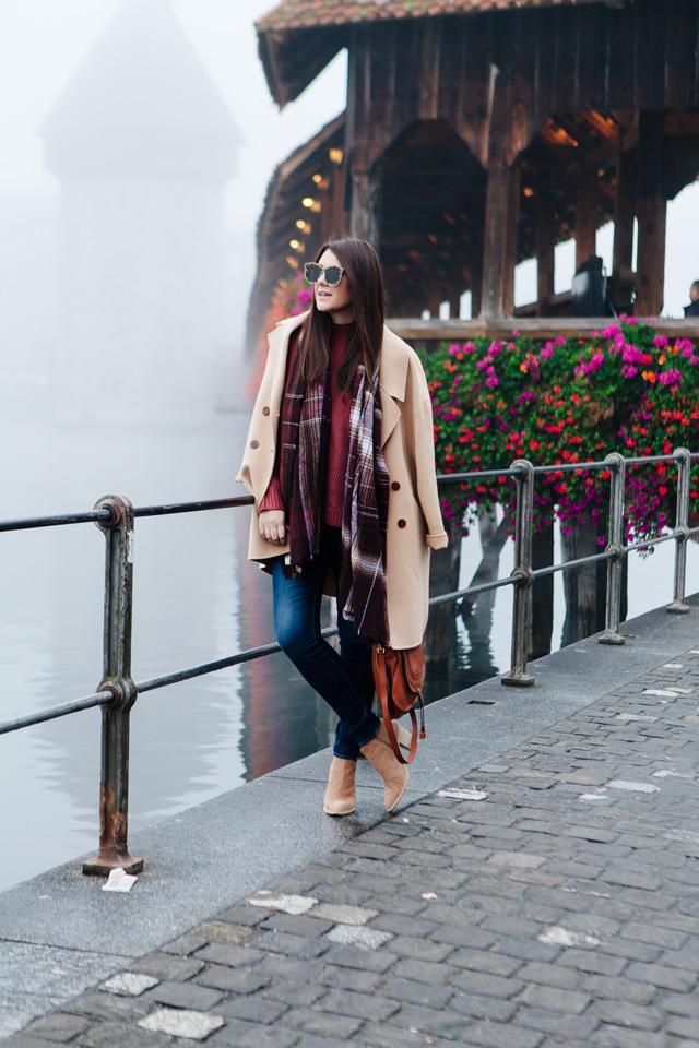 Burgundy sweater with plaid scarf and camel coat in Lucerne. 