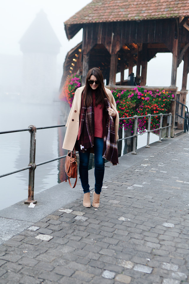 Burgundy sweater with plaid scarf and camel coat in Lucerne. 