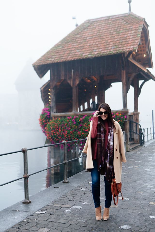 Burgundy sweater with plaid scarf and camel coat in Lucerne. 