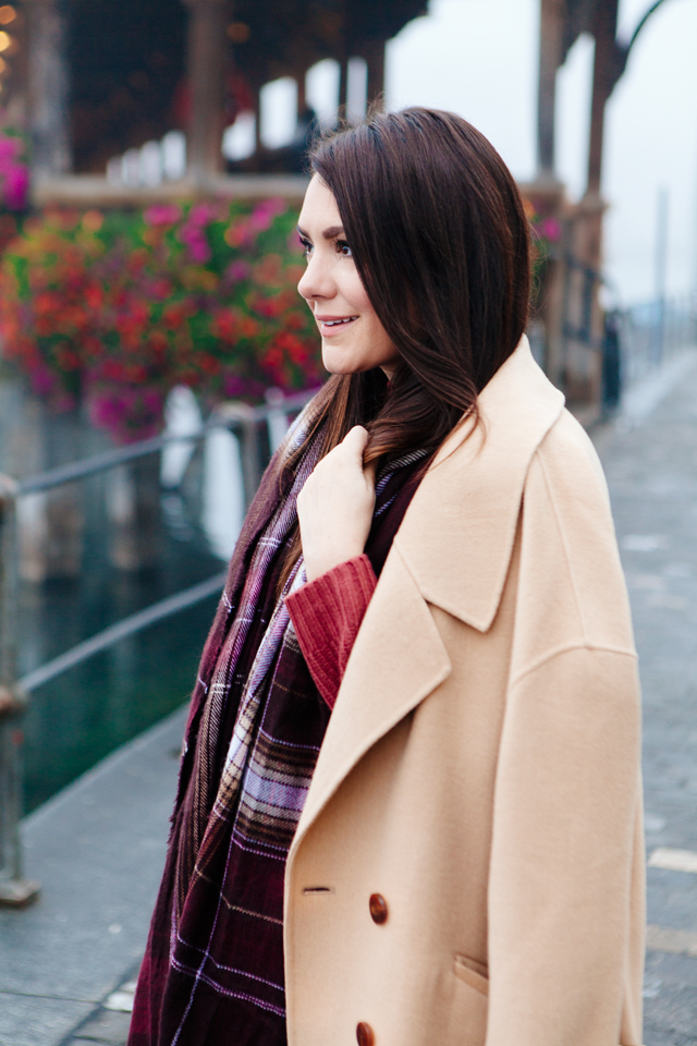 Burgundy sweater with plaid scarf and camel coat in Lucerne. 