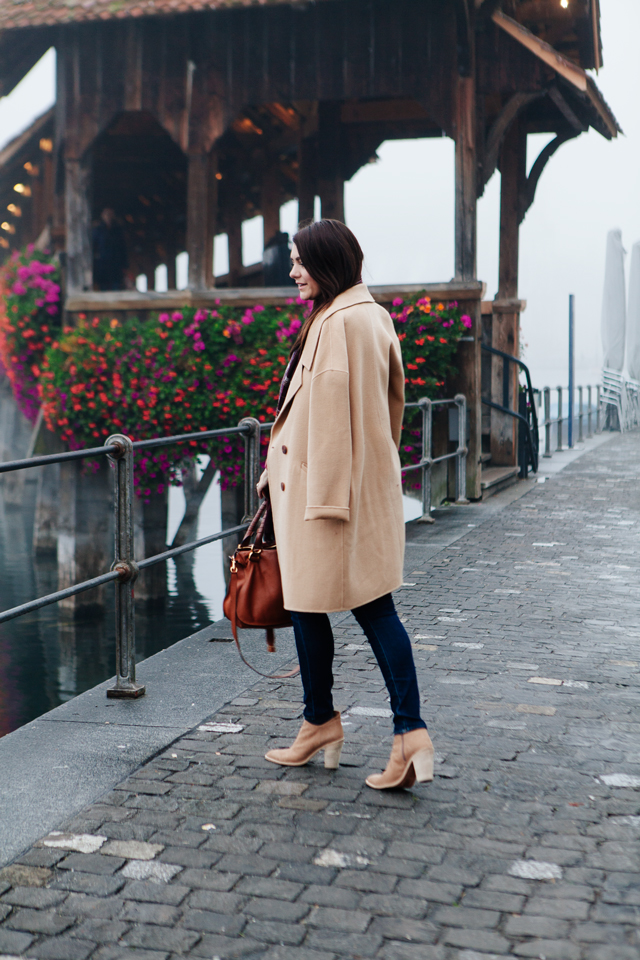 Burgundy sweater with plaid scarf and camel coat in Lucerne. 