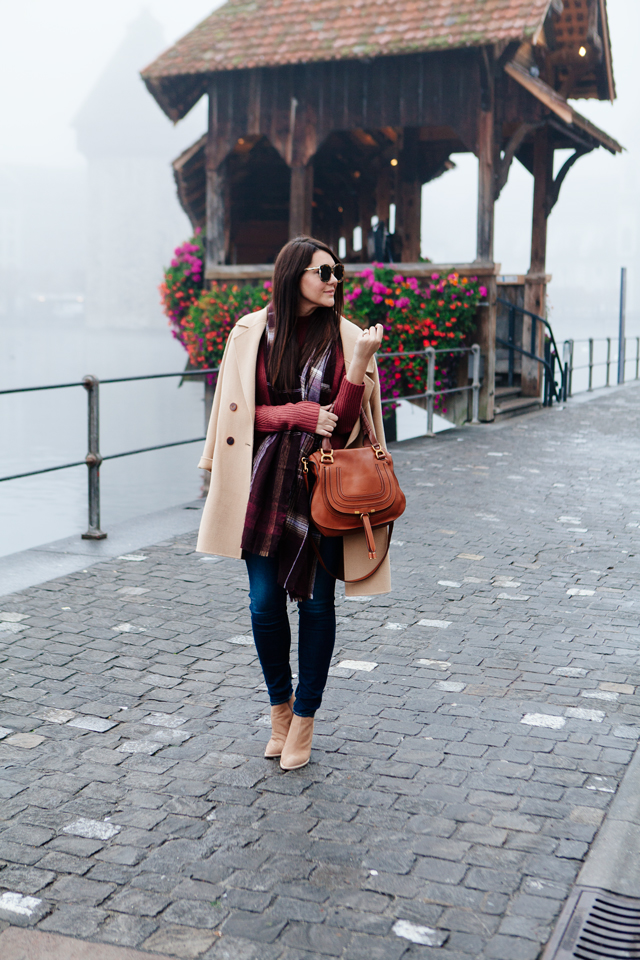 Burgundy sweater with plaid scarf and camel coat in Lucerne. 