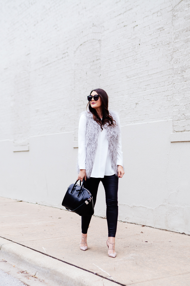 Grey faux fur vest with white blouse and black leggings outfit.
