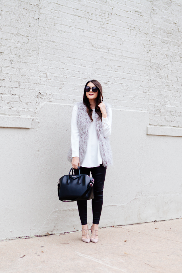 Grey faux fur vest with white blouse and black leggings outfit.