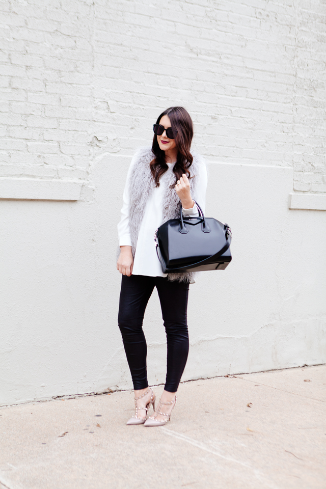 Grey faux fur vest with white blouse and black leggings outfit.