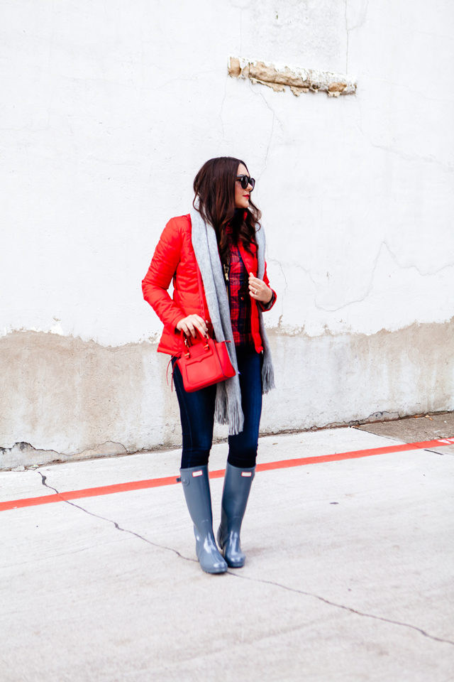 Bright red puffer jacket with layered plaid vest outfit.