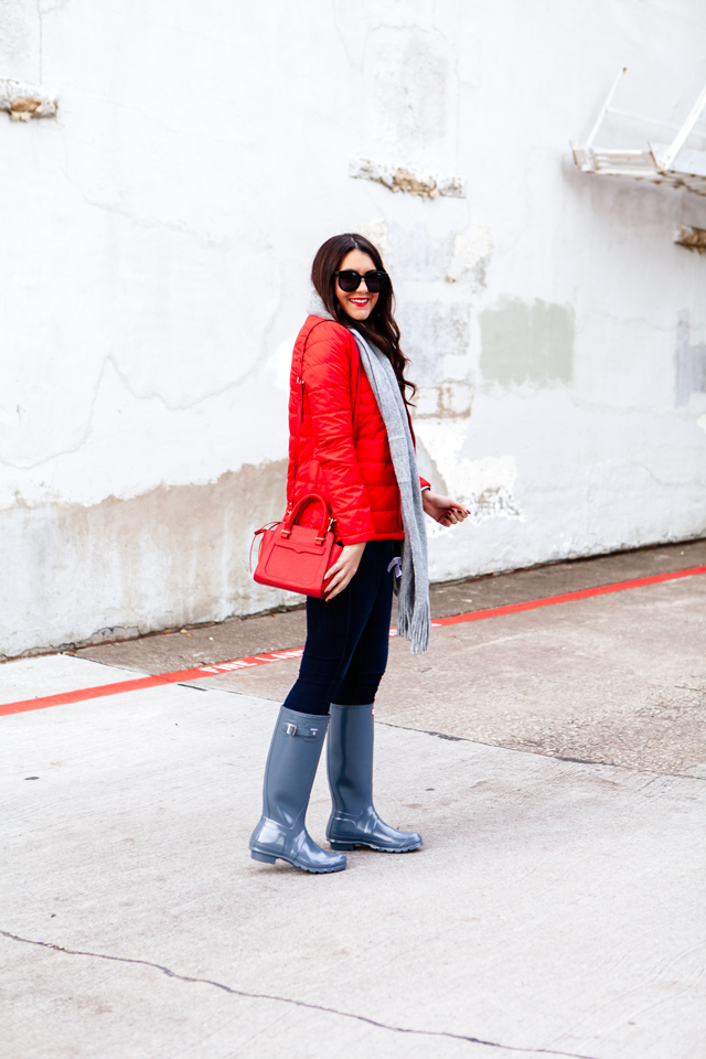 Bright red puffer jacket with layered plaid vest outfit.