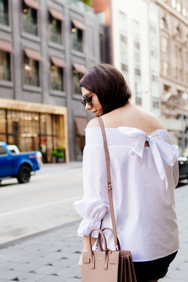 white off the shoulder top with cut offs and espadrille sneakers