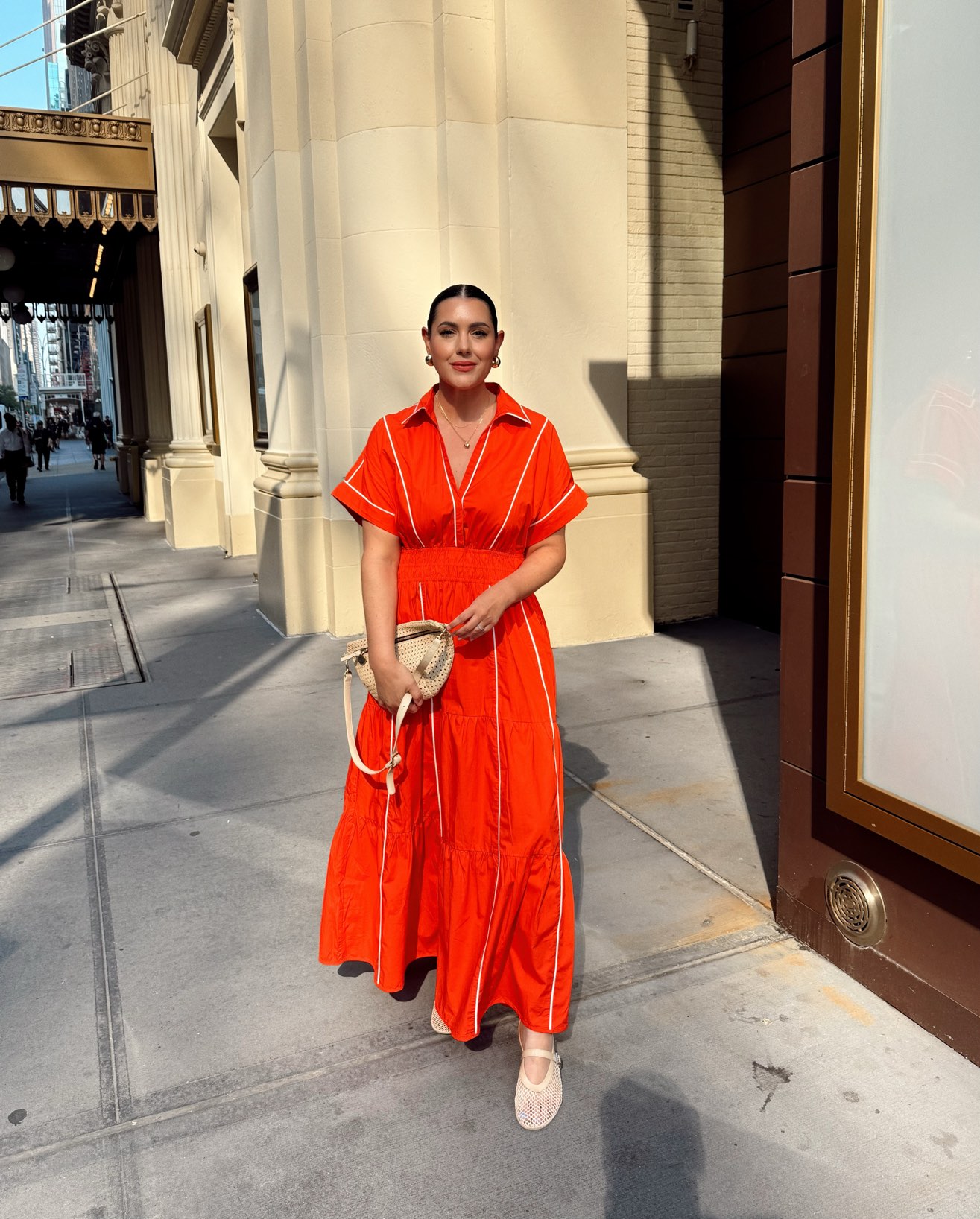 woman in red maxi dress on streets of New York in direct sunlight